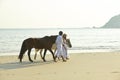 A couple walking horses on beach Royalty Free Stock Photo