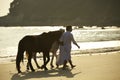 A couple walking horses on beach Royalty Free Stock Photo