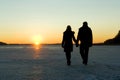 Couple walking on ice at sunset Royalty Free Stock Photo