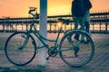 A couple walking next to a vintage bicycle near the Rio Tinto pier in Huelva Spain as the sun goes down