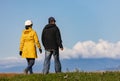 Couple walking in park in sunny autumn day. Man and woman walking outdoor in cold autumn day