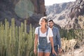 Couple walking past cactus in the mountains Royalty Free Stock Photo