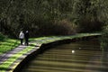 Couple walking on path near canal in spring.