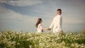 Couple walking in poppy field holding hands smiling, love and romance Royalty Free Stock Photo