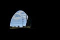 Couple walking on the railroad view from the tunnel. Black background and bright exit from the tunnel with a blue sky