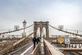 Couple Walking in the Rain on Brooklyn Bridge on a Cold Day of Winter, Manhattan. New York City, USA