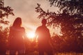 Couple walking in spring forest. Young man and girl holding hands at sunset. Royalty Free Stock Photo