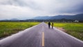 Couple walking a straight road leading into the distance Royalty Free Stock Photo