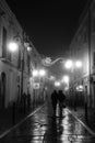 Couple walking on the streets decorated with christmas lights. Royalty Free Stock Photo