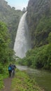 Couple walking towards the Condor Machay waterfall in the middle of the Andean forest near the city of Quito