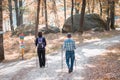 A couple walking trough a park with hiking sticks. forest, love, sport, jogging, pensioner, sporty;