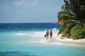 Couple walking at white sand beach Maldives