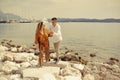 A couple walks along the beach against the backdrop of the sea and mountains. Travel of lovers. Love and honeymoon. Man and girl