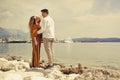 A couple walks along the beach against the backdrop of the sea and mountains. Travel of lovers. Love and honeymoon. Man and girl