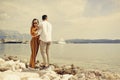 A couple walks along the beach against the backdrop of the sea and mountains. Travel of lovers. Love and honeymoon. Man and girl