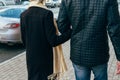 A couple walks, walks through the city, holding hands, arm, rear view.