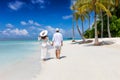Couple walks down a tropical beach in the Maldives islands Royalty Free Stock Photo
