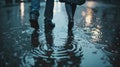 A couple walks hand in hand through the rainsoaked streets their footsteps causing small ripples in the puddles beneath Royalty Free Stock Photo