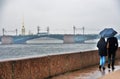 A couple walks in Saint Petersburg under umbrella