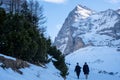 Couple walks in the snow on a sunny day, photographed between Kleine Scheidegg and Wengen Switzerland on the Fox Run trail.