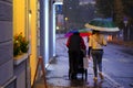 Couple walks with their child in the rain