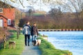 A couple walks their pet dogs along a canal in England