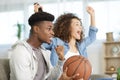 Couple watching basketball game on sofa at home