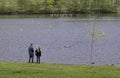 Couple Watching Dog Fetching Stick in Water