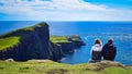Couple watching Neist Point and Lighthouse, Isle of Skye, Scotland landmark Royalty Free Stock Photo
