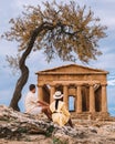 Couple Watching Old Temple During Vacation At The Italian Island Sicily Visiting The Archelogical Site Of Agrigento