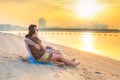 Couple watching romantic sunrise on the beach