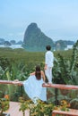 Couple watching sunrise over Phang Nga Bay, Thailand At Samet Nang Chee viewpoint, the most beautiful unseen corner in Thailand