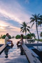 couple watching sunset in infinity pool on a luxury vacation in Thailand, man and woman watching sunset on the edge of a Royalty Free Stock Photo