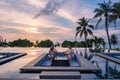 couple watching sunset in infinity pool on a luxury vacation in Thailand, man and woman watching sunset on the edge of a Royalty Free Stock Photo