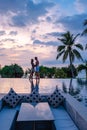 couple watching sunset in infinity pool on a luxury vacation in Thailand, man and woman watching sunset on the edge of a Royalty Free Stock Photo