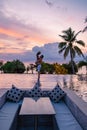 couple watching sunset in infinity pool on a luxury vacation in Thailand, man and woman watching sunset on the edge of a Royalty Free Stock Photo