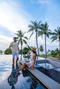 couple watching sunset in infinity pool on a luxury vacation in Thailand, man and woman watching sunset on the edge of a Royalty Free Stock Photo
