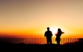 Couple watching sunset, lovers with orange background, silhouette Royalty Free Stock Photo