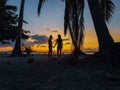 Couple watching sunset with palm trees in Candaraman Island in Balabac Philippines Royalty Free Stock Photo