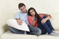 Couple watching television together at home sofa couch looking bored frustrated switching channels Royalty Free Stock Photo