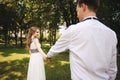 Couple in wedding attire is in the hands against the backdrop of the field at sunset, the bride and groom Royalty Free Stock Photo