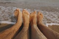 Couple wet feet in sand close up on sunny beach with waves. Couple in love relaxing together on sandy seashore. Family summer Royalty Free Stock Photo