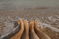 Couple wet feet in sand close up on sunny beach with waves. Couple in love relaxing together on sandy seashore. Family summer Royalty Free Stock Photo