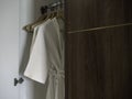 Couple of white clean bathrobes hanging on the wooden hangers. Royalty Free Stock Photo