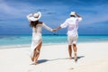 Couple in white summer clothes running happy on a tropical beach Royalty Free Stock Photo