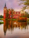 Couple of white swans on the pond in famous Muskau Park at autumn evening. Muskau Castle on background. Germany Royalty Free Stock Photo