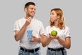 Couple in white t-shirts with popcorn and apple Royalty Free Stock Photo