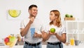 Couple in white t-shirts with popcorn and apple Royalty Free Stock Photo