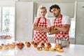 Couple of wife and husband cooking pastries at the kitchen skeptic and nervous, disapproving expression on face with crossed arms Royalty Free Stock Photo