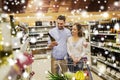 Couple with wine and shopping cart at liquor store Royalty Free Stock Photo